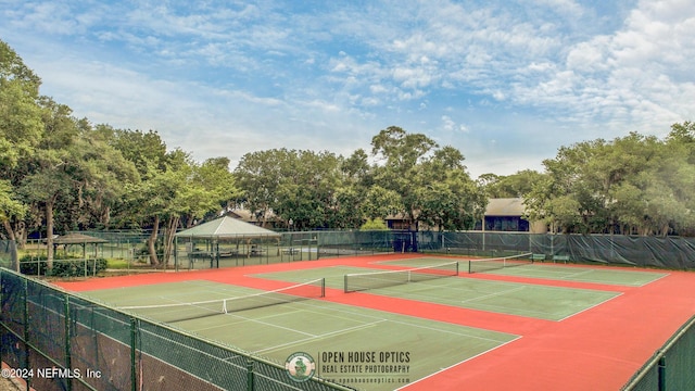 view of tennis court with community basketball court and fence