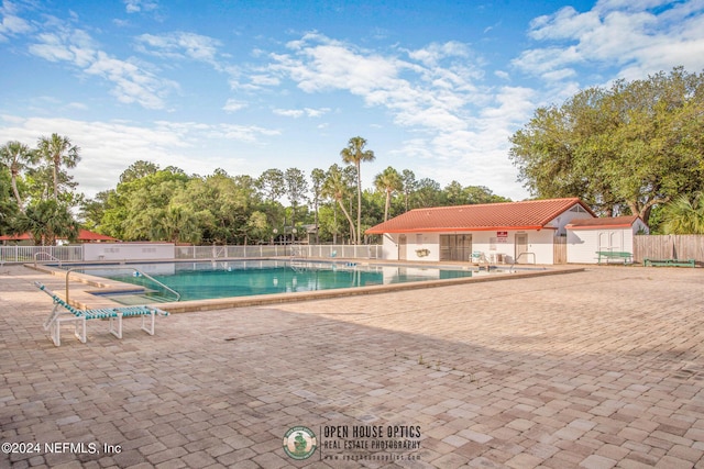 community pool featuring a patio area and fence