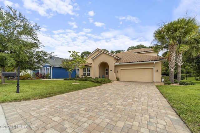 mediterranean / spanish house with a garage and a front lawn