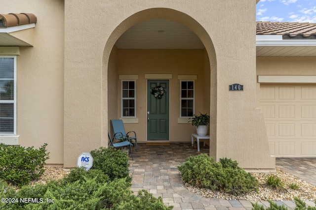 view of exterior entry with a garage