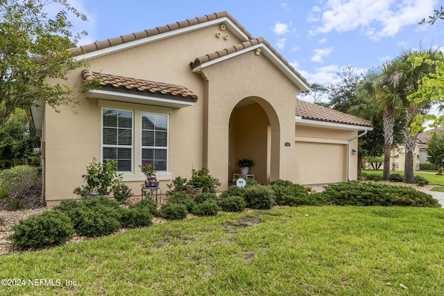 mediterranean / spanish home with a front lawn and a garage