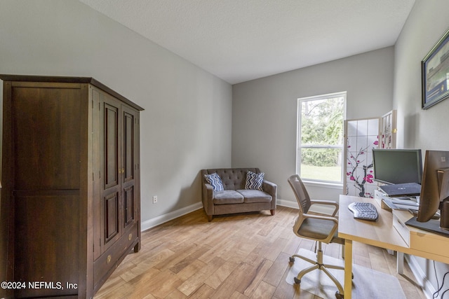 office area with light hardwood / wood-style flooring and a textured ceiling