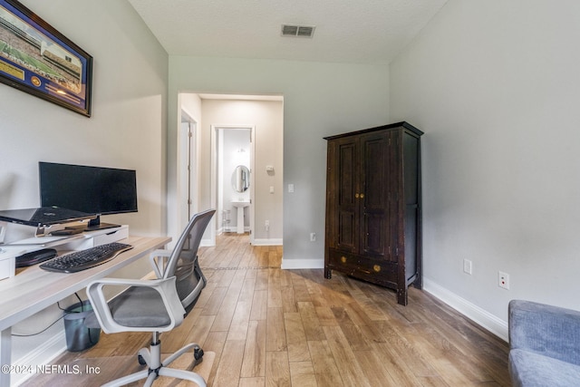 office area with hardwood / wood-style floors and a textured ceiling