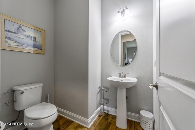 bathroom featuring wood-type flooring, toilet, and sink