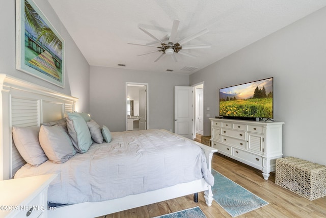 bedroom with light wood-type flooring, ensuite bath, a textured ceiling, and ceiling fan