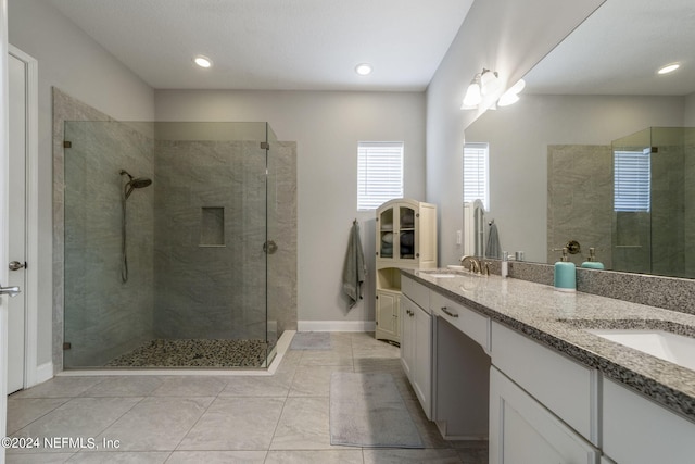 bathroom with tiled shower and vanity