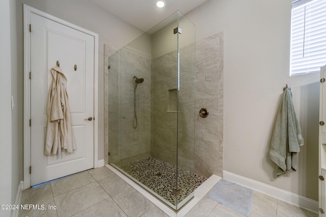 bathroom with tiled shower and tile patterned floors