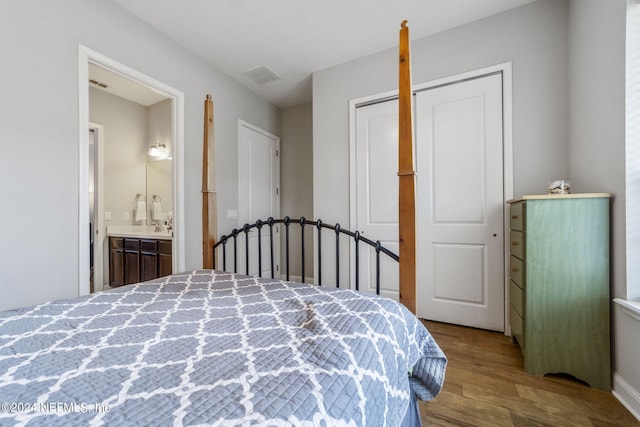 bedroom featuring light wood-type flooring, a closet, and ensuite bathroom