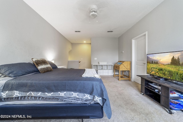 carpeted bedroom featuring a textured ceiling and ceiling fan