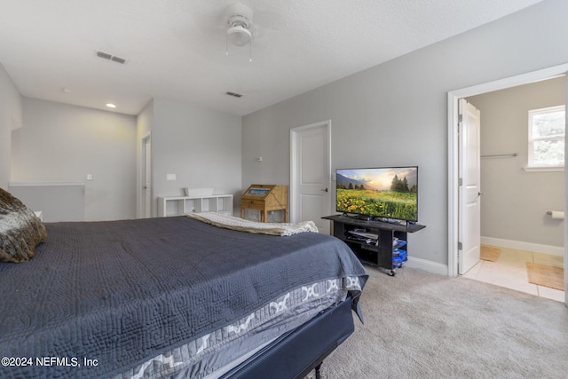 bedroom featuring light carpet and ensuite bath