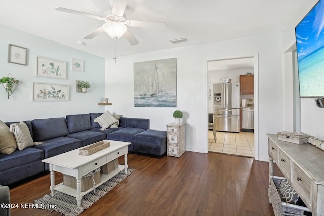 living room featuring ceiling fan and dark wood-type flooring