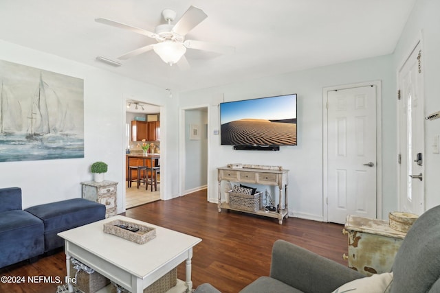 living room featuring dark wood-type flooring and ceiling fan