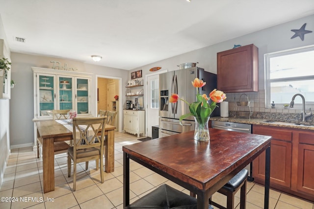 kitchen with sink, light tile patterned floors, tasteful backsplash, and stainless steel appliances