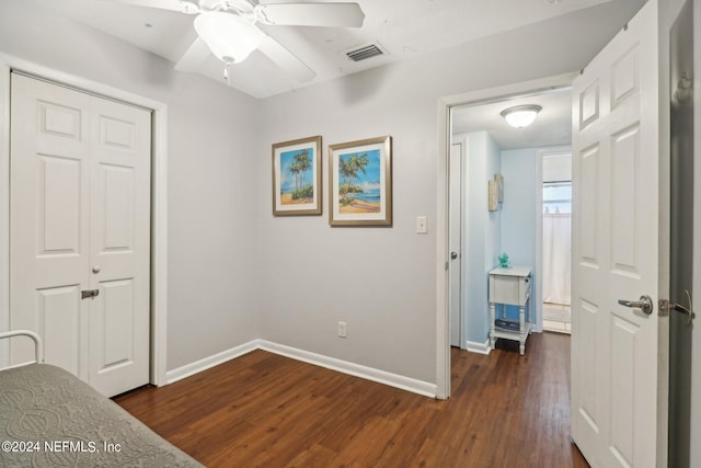 unfurnished bedroom with a closet, ceiling fan, and dark wood-type flooring