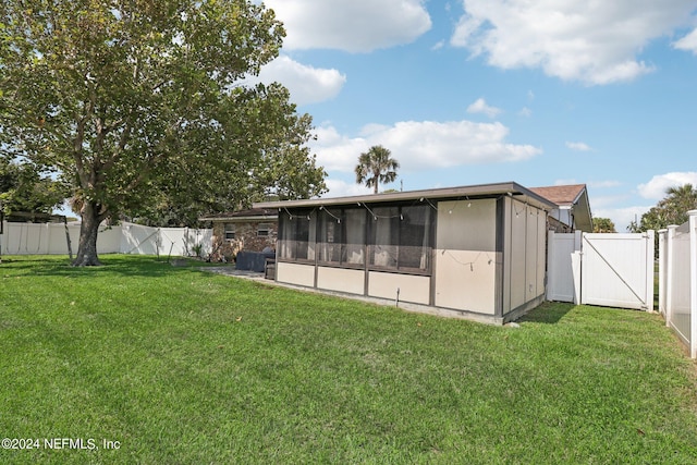 back of property with a sunroom and a lawn