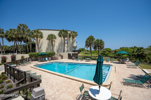 view of swimming pool featuring area for grilling and a patio