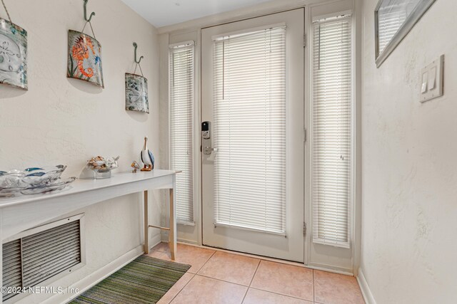 entryway with light tile patterned floors and a healthy amount of sunlight