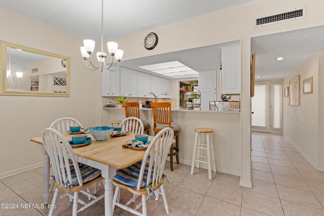 tiled dining space featuring a chandelier