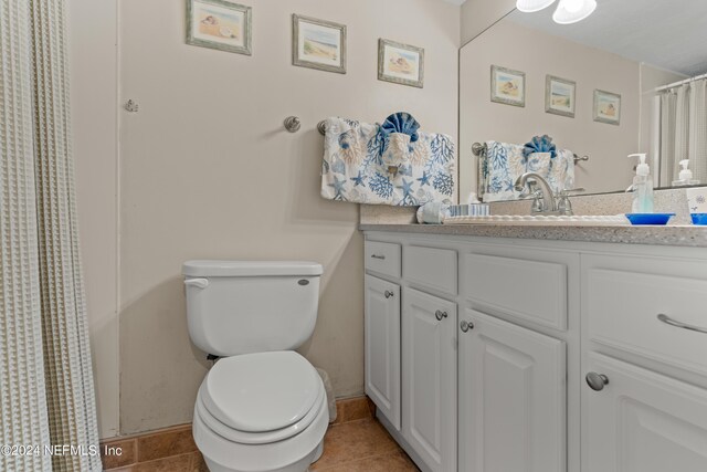 bathroom with tile patterned flooring, vanity, and toilet