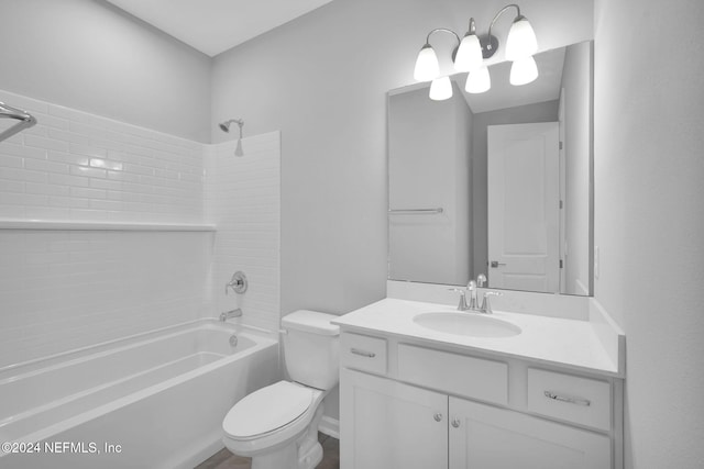 full bathroom featuring vanity, tiled shower / bath combo, and toilet