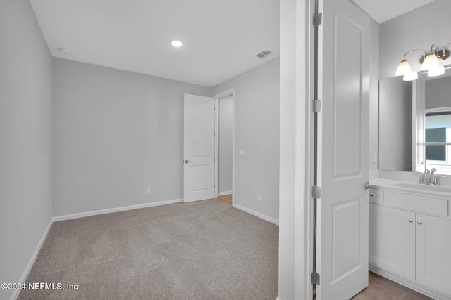 unfurnished bedroom featuring sink and light colored carpet