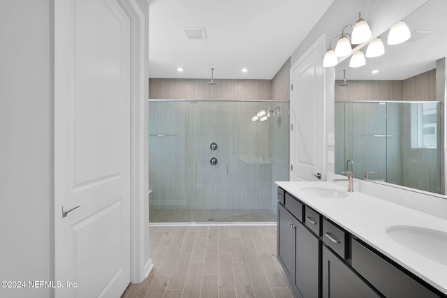 bathroom with a shower with door and vanity