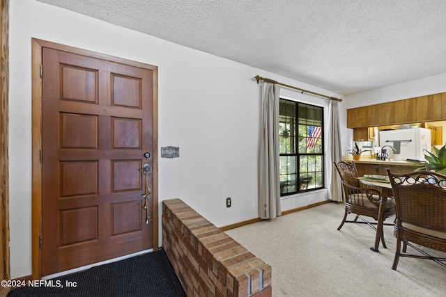 carpeted dining area featuring a textured ceiling