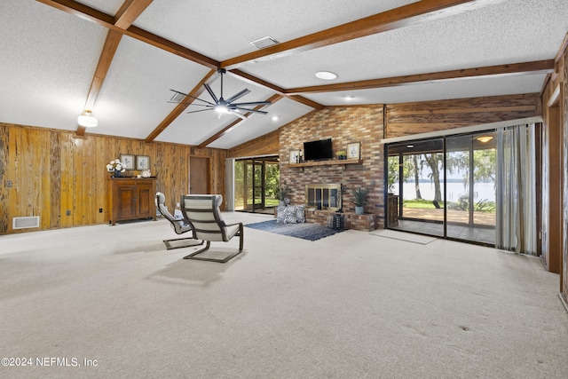 unfurnished living room with plenty of natural light, a textured ceiling, and a brick fireplace