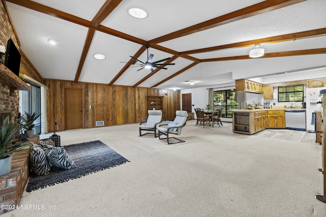 carpeted living room featuring ceiling fan, wooden walls, and lofted ceiling with beams