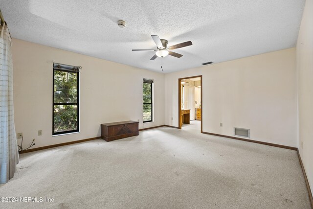 carpeted spare room with ceiling fan and a textured ceiling