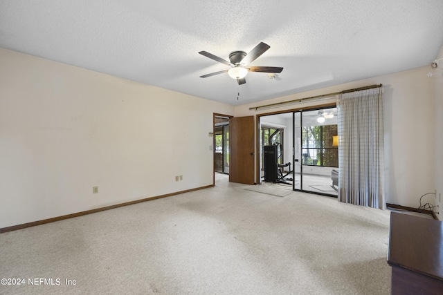 carpeted empty room with ceiling fan and a textured ceiling