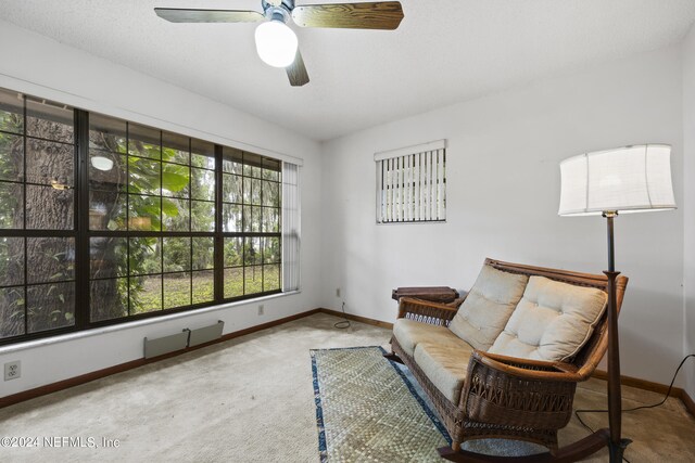 living area featuring carpet flooring and ceiling fan