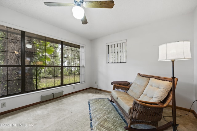 sitting room with ceiling fan and carpet