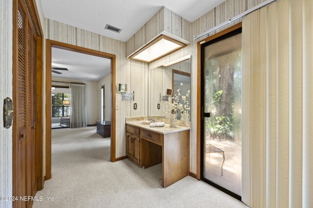 bathroom with vanity, ceiling fan, and a textured ceiling