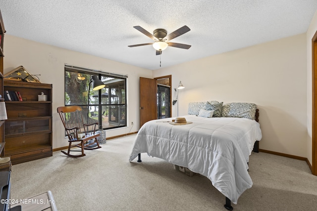 carpeted bedroom featuring access to outside, ceiling fan, and a textured ceiling