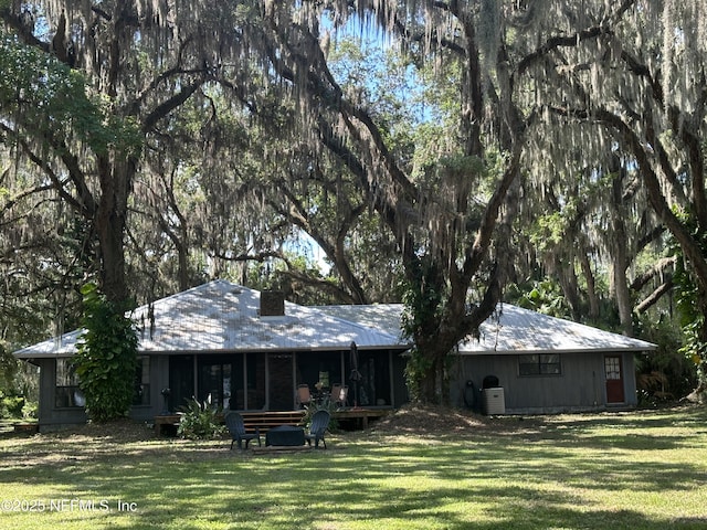 rear view of house with a yard and central AC