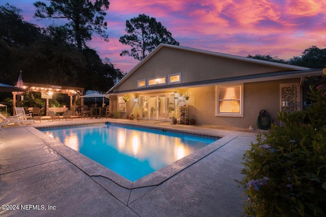 pool at dusk with a patio