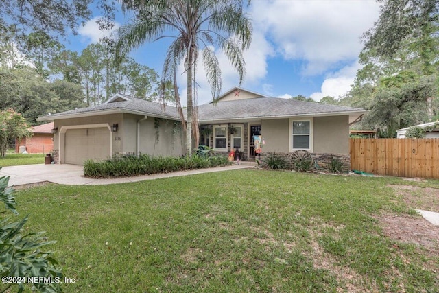 ranch-style home with a garage and a front lawn