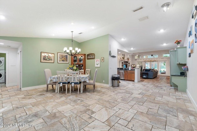 dining space featuring stacked washer and dryer, lofted ceiling, and a chandelier