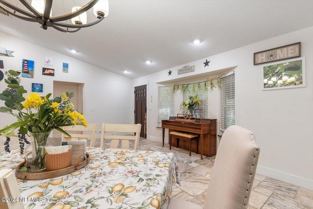 dining area with vaulted ceiling, a chandelier, and a textured ceiling