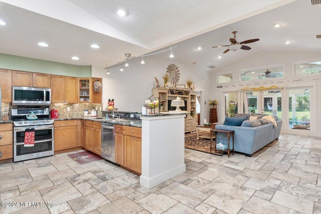 kitchen with lofted ceiling, dark stone counters, kitchen peninsula, stainless steel appliances, and decorative backsplash