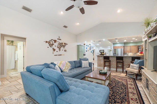 living room with ceiling fan and high vaulted ceiling