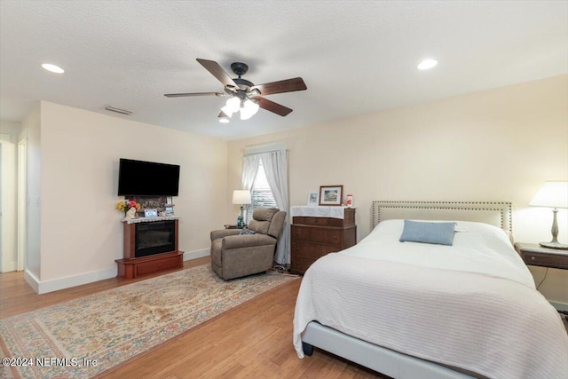 bedroom featuring ceiling fan, a textured ceiling, and light wood-type flooring