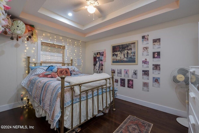 bedroom featuring dark hardwood / wood-style flooring and a raised ceiling