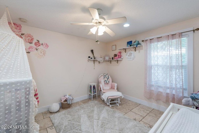 bedroom with ceiling fan and a textured ceiling