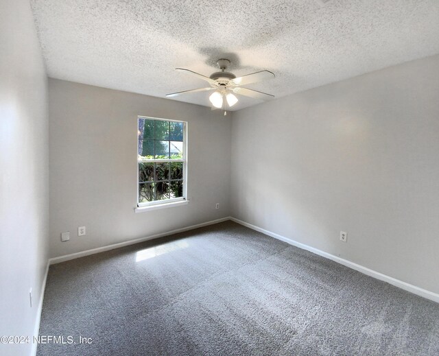 carpeted spare room featuring a textured ceiling and ceiling fan