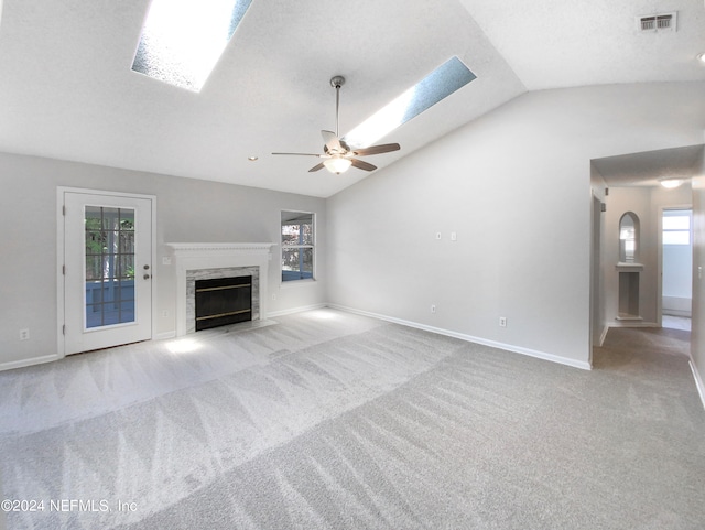 unfurnished living room with a fireplace, light carpet, lofted ceiling, and ceiling fan