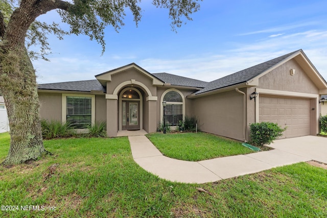 ranch-style home with a garage and a front yard