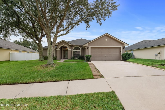 ranch-style house with a garage and a front lawn