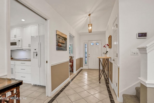 foyer featuring light tile patterned floors, vaulted ceiling, recessed lighting, and baseboards